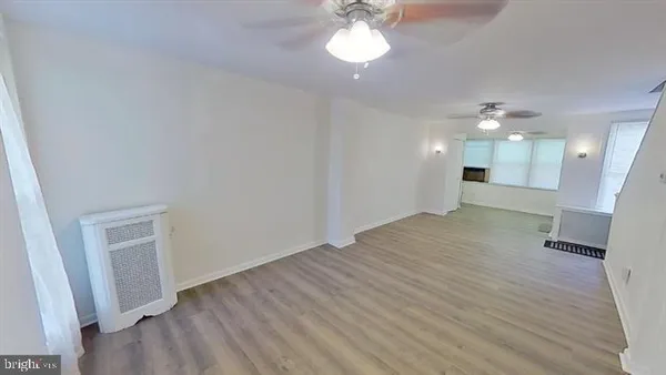 a view of a big room with wooden floor and a large mirror