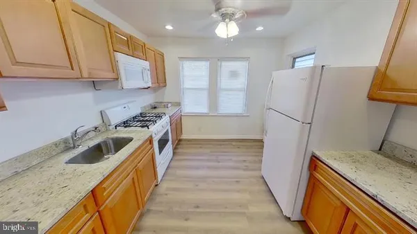 a kitchen with a sink a refrigerator and cabinets