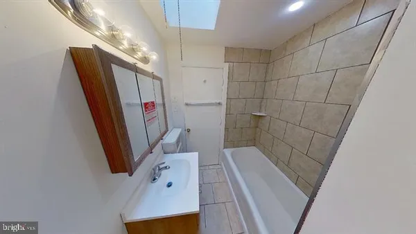 a bathroom with a sink a toilet a mirror and shower