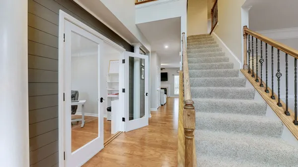 a view of a hallway with wooden floor and staircase