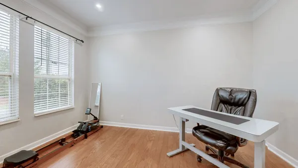 a view of a workspace with furniture and wooden floor