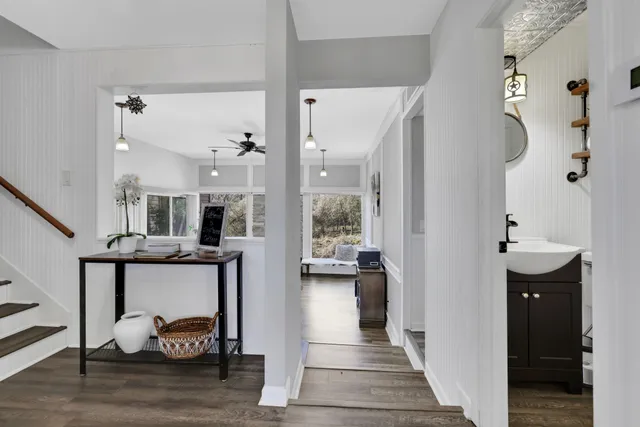 a view of hall way with furniture and wooden floor