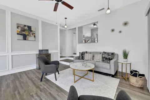 a living room with furniture and a wooden floor