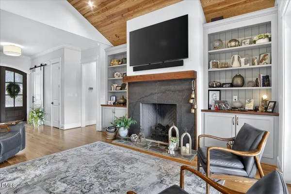 a living room with fireplace furniture flat screen tv and a rug