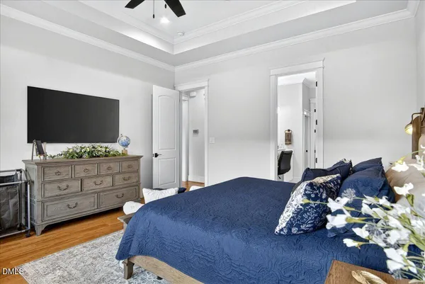 a bedroom with a bed and a lamp on dresser