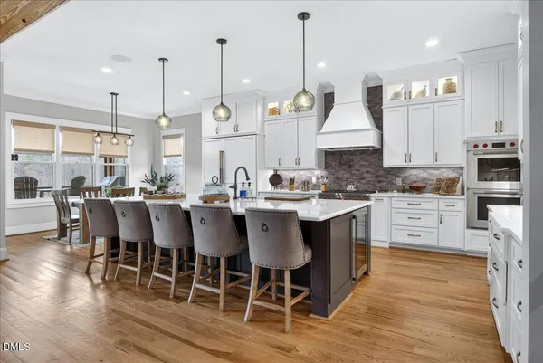 a view of a dining room and livingroom with furniture wooden floor a chandelier