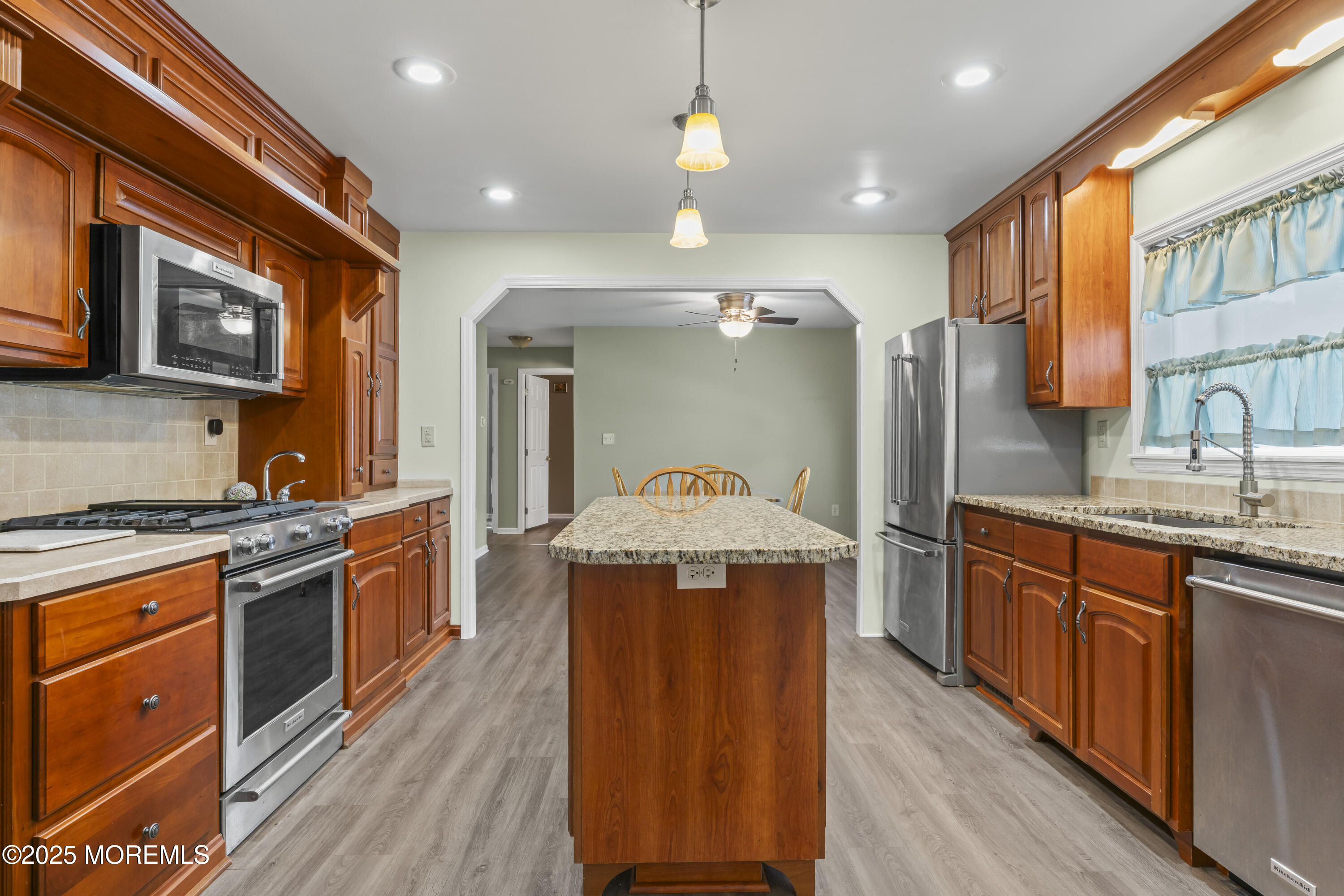 75 Village Road Morganville, NJ 07751 - Photo 7 of 27 a kitchen with stainless steel appliances granite countertop wooden floors a stove a sink and a refrigerator