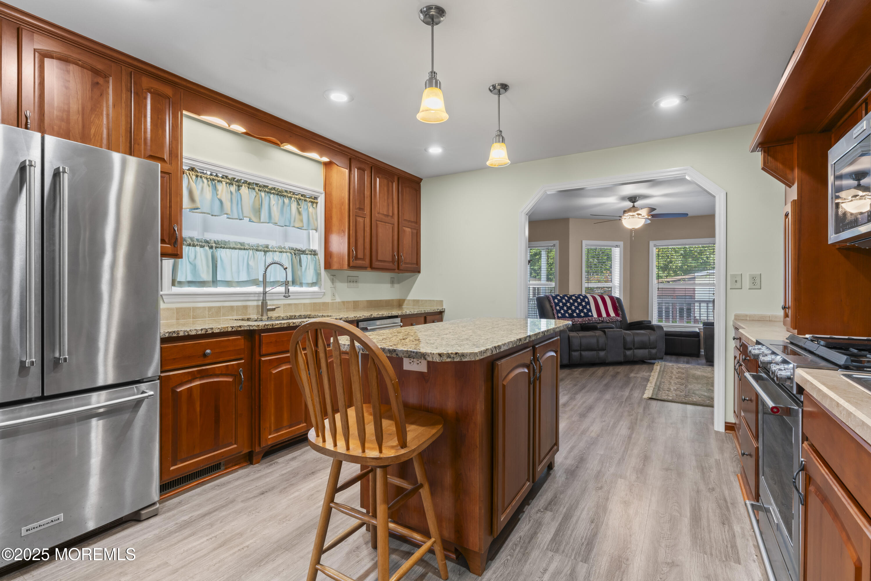 75 Village Road Morganville, NJ 07751 - Photo 10 of 27 a kitchen with stainless steel appliances granite countertop a refrigerator a sink dishwasher a stove and white countertops with wooden floor