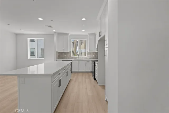 a large white kitchen with a sink