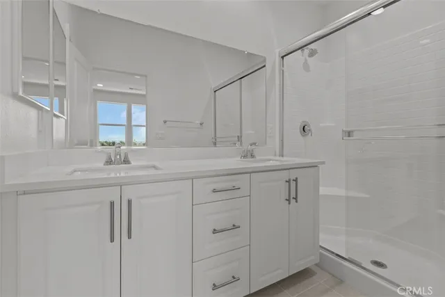 a bathroom with a shower sink vanity and mirror