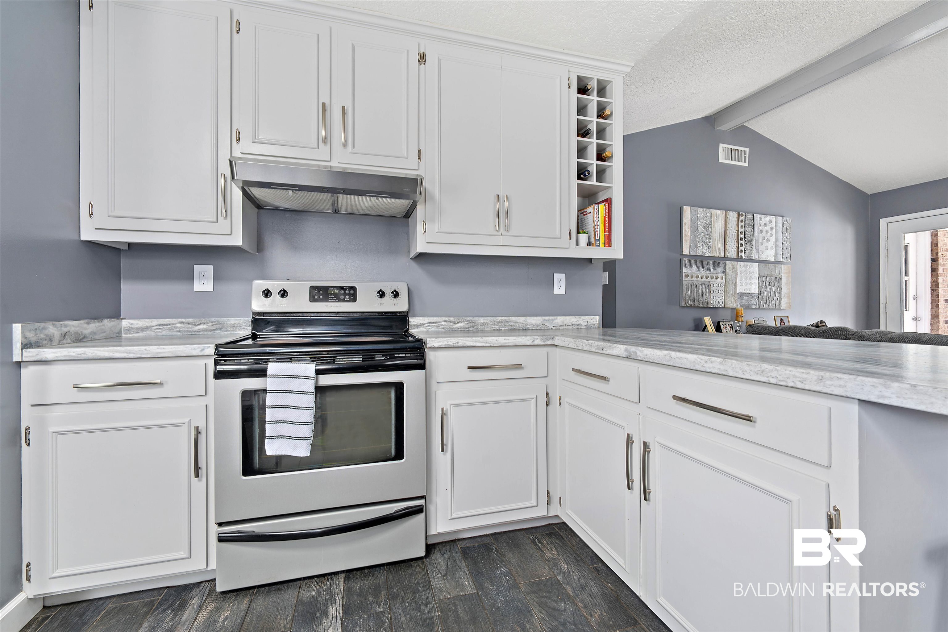 2000 Campfire Drive Semmes, AL 36575 - Photo 10 of 26 Kitchen featuring white cabinets, dark hardwood / wood-style floors, stainless steel electric range, and vaulted ceiling with beams
