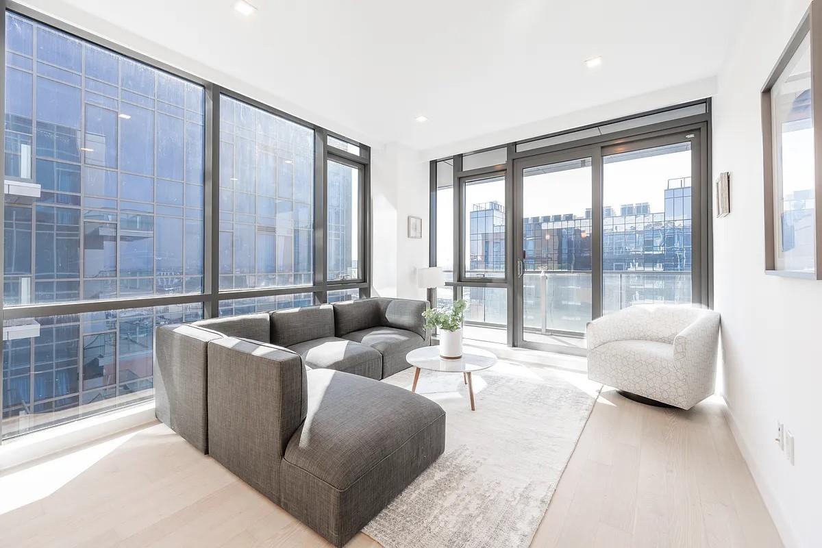 33-66 Farrington Street, Unit 14I Queens, NY 11354 - Photo 2 of 9 a living room with furniture and a floor to ceiling window