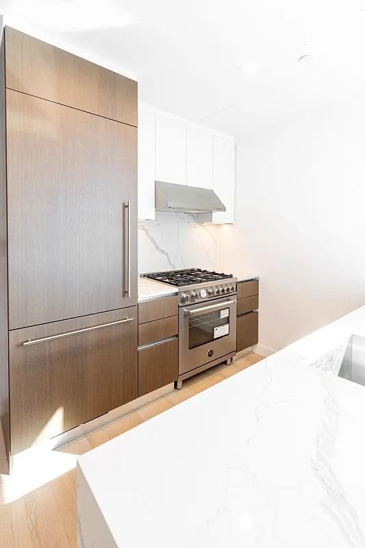 33-66 Farrington Street, Unit 14I Queens, NY 11354 - Photo 3 of 9 a kitchen with a refrigerator and a stove