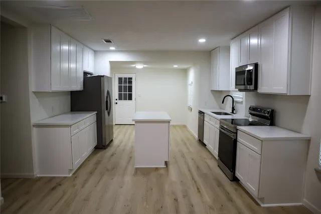 en empty room with windows and chandelier fan