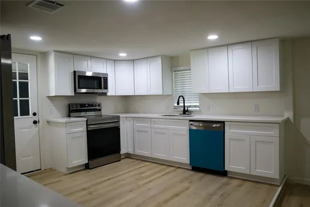 a kitchen with stainless steel appliances granite countertop a refrigerator and a stove