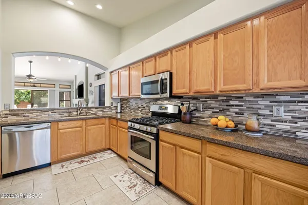 a kitchen with stainless steel appliances granite countertop a stove a sink and a microwave