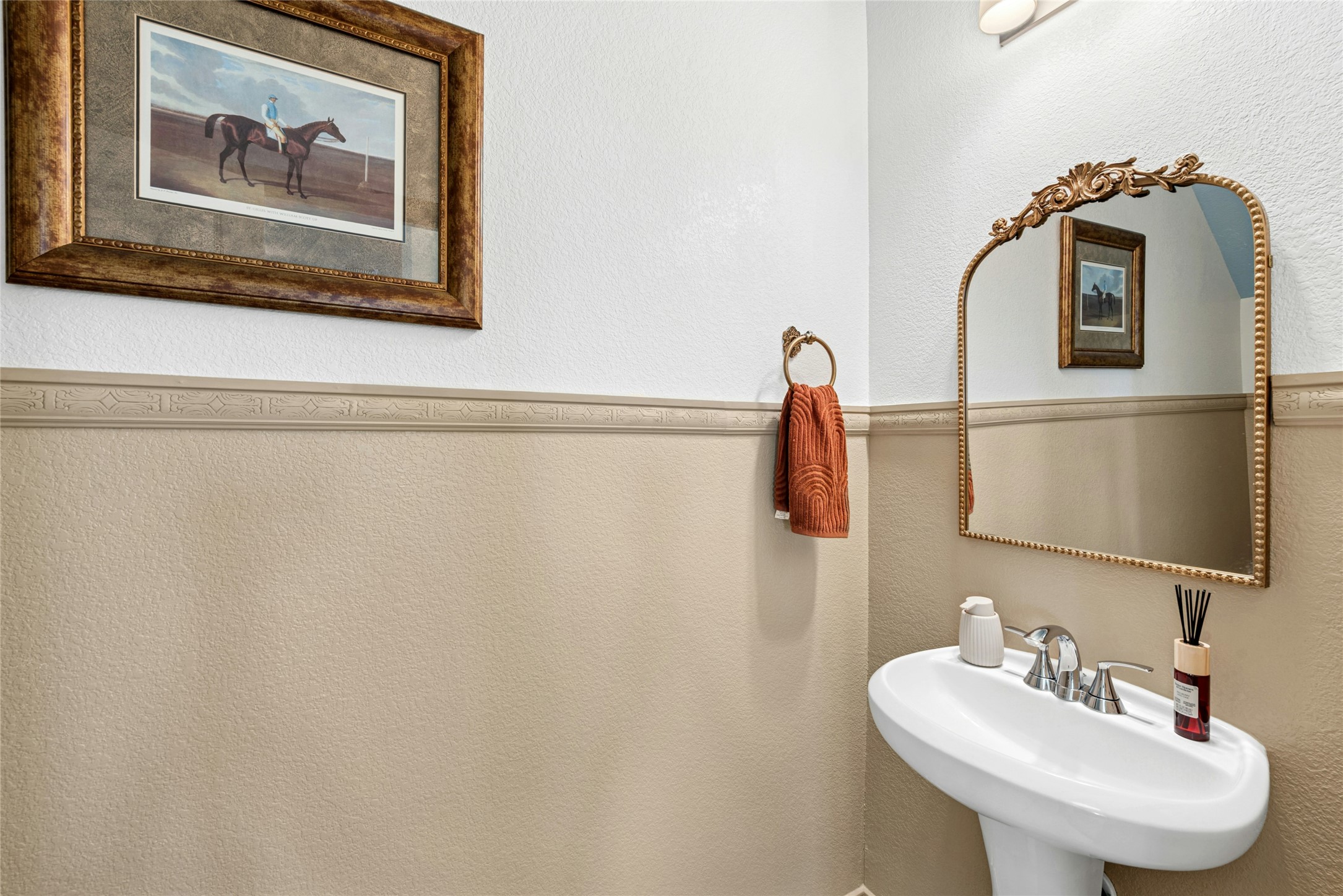 2001 Saskatoon Street Georgetown, TX 78626 - Photo 11 of 40 A stylish first-floor bathroom featuring a textured accent wall, decorative molding, and a classic pedestal sink—creating a refined and elegant space for guests.