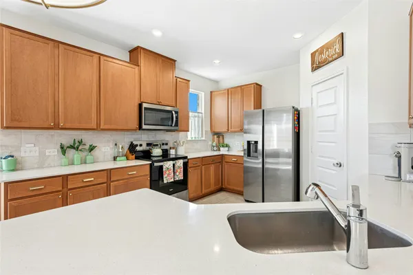 a kitchen with stainless steel appliances granite countertop a refrigerator sink and microwave