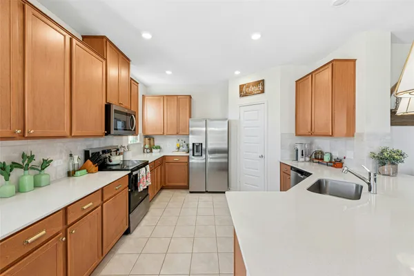 a kitchen with a sink a stove cabinets and a refrigerator