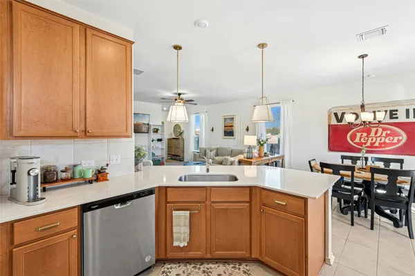 a kitchen with stainless steel appliances a sink stove and white cabinets next to a window