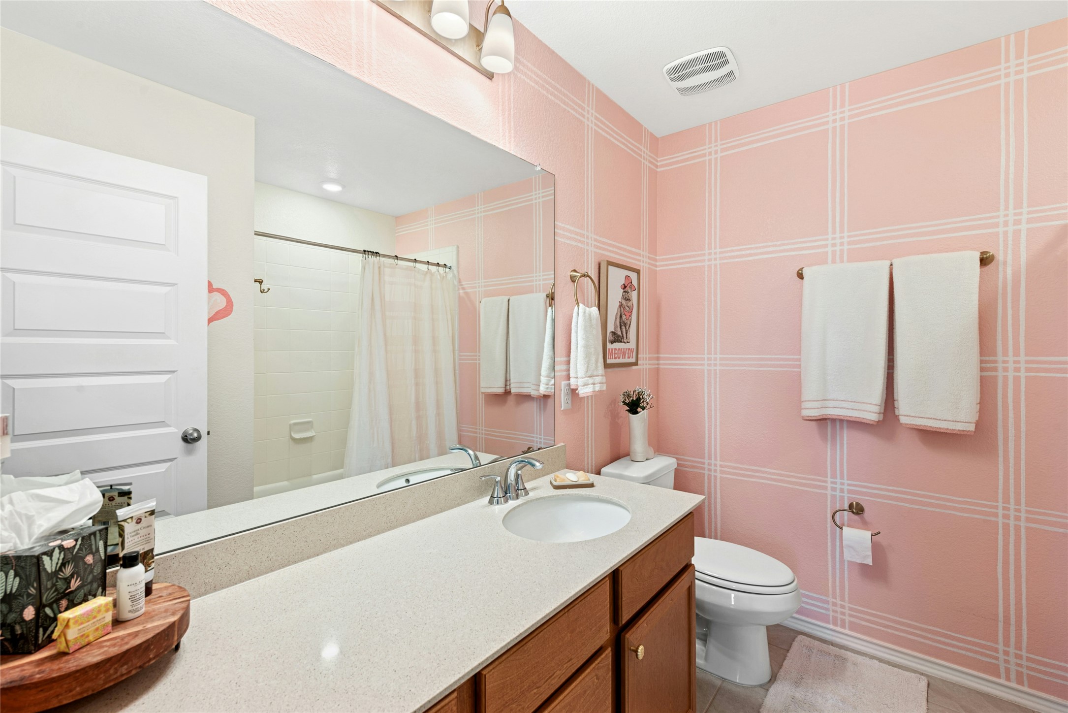 2001 Saskatoon Street Georgetown, TX 78626 - Photo 29 of 40 This full bathroom offers a bright and inviting design, featuring a tub/shower combination, an extra-long vanity for ample counter space, and beautifully curated decorative walls and lighting that enhance its stylish appeal.