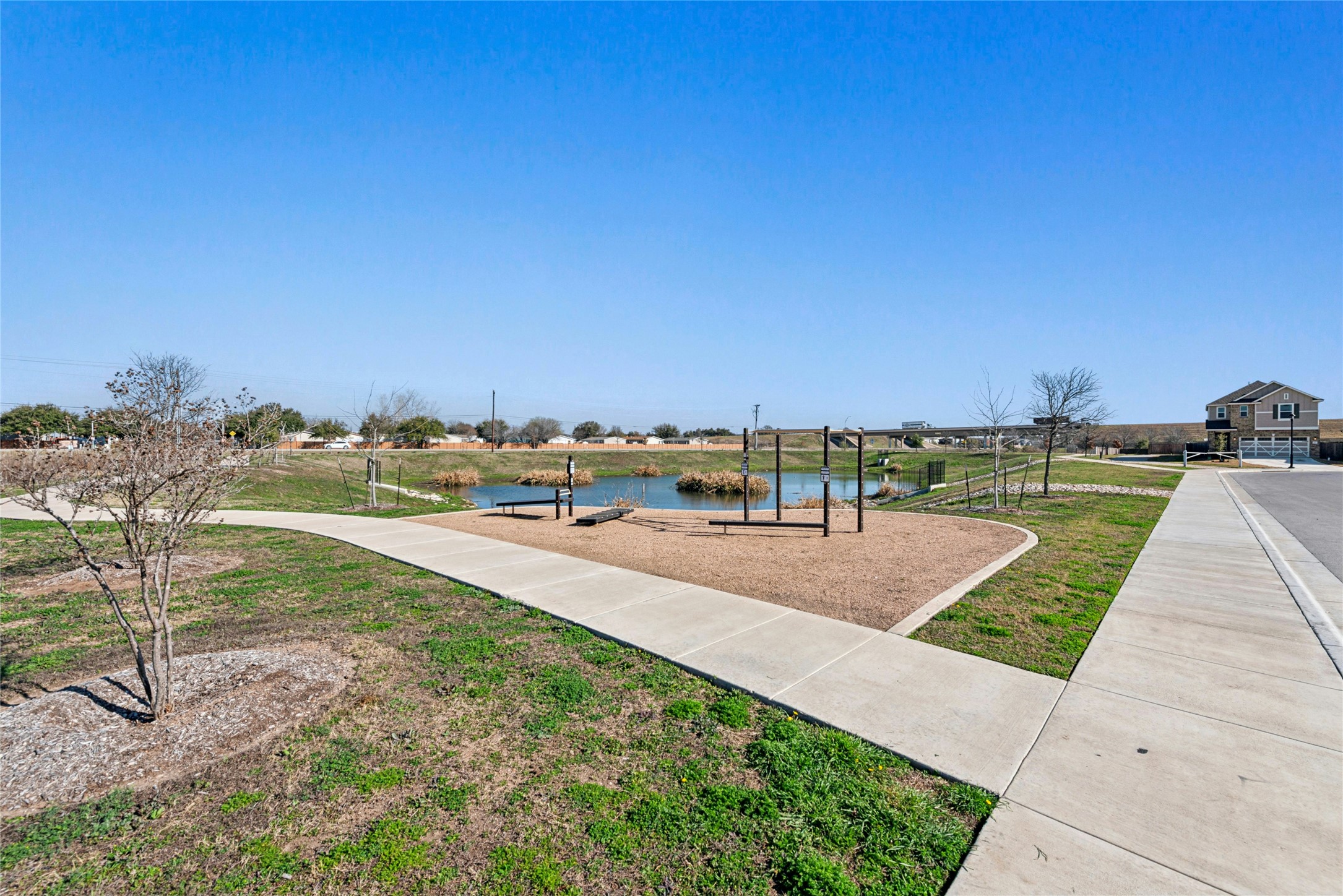 2001 Saskatoon Street Georgetown, TX 78626 - Photo 37 of 40 Enjoy a serene view of the community’s exercise area, overlooking a tranquil pond and surrounded by scenic walking trails perfect for biking, walking, running, and dog-walking. Sidewalks and a grassy knoll provide additional space for outdoor activities, creating an inviting and versatile setting for an active lifestyle.