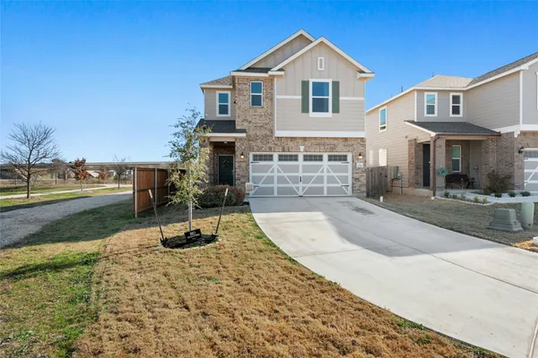 a view of a house with backyard and trees in the background