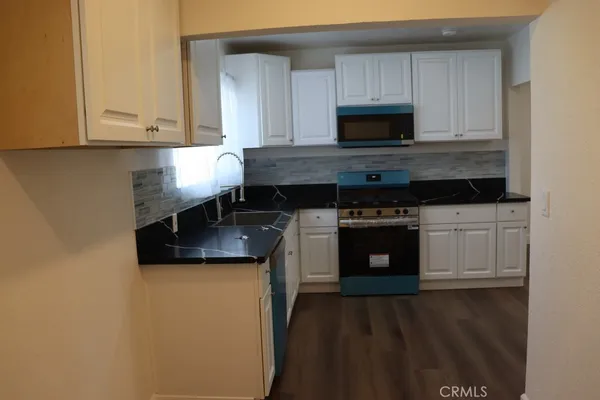 a view of a kitchen with wooden floor and a sink