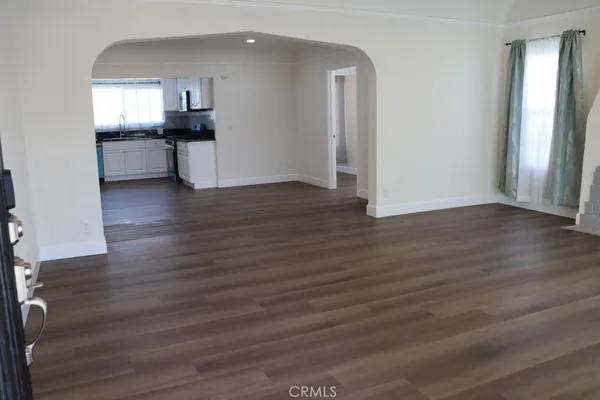 an empty room with wooden floor and fireplace