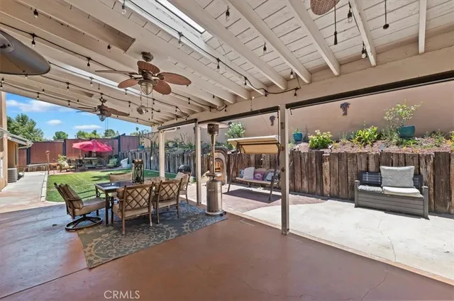 a view of a roof deck with couches chairs and wooden floor