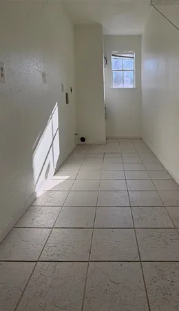 a view of a livingroom with an empty space and a window