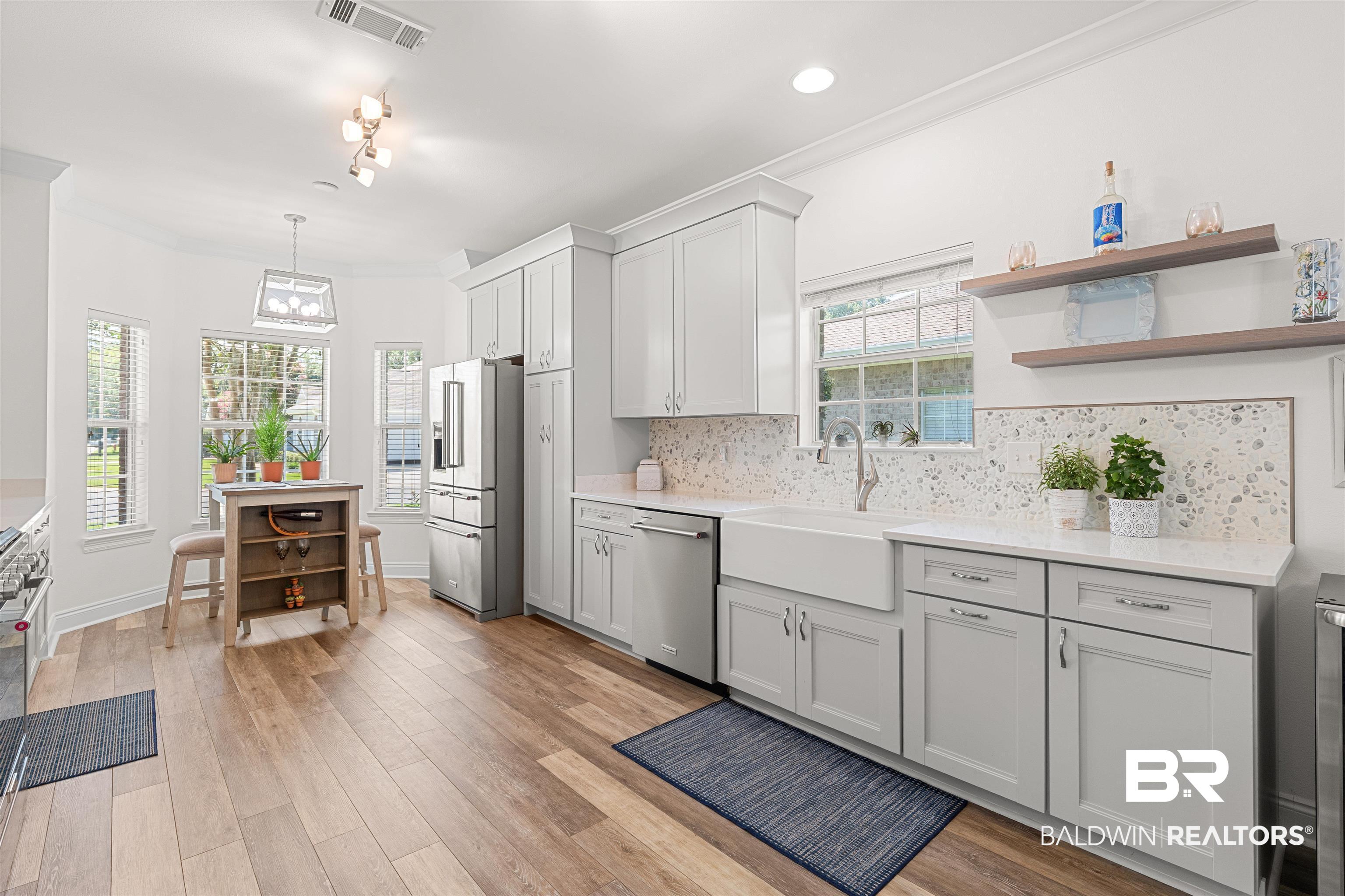 141 Mark Twain Loop Foley, AL 36535 - Photo 6 of 55 Kitchen featuring stainless steel appliances, light countertops, decorative backsplash, light wood-style floors, and open shelves