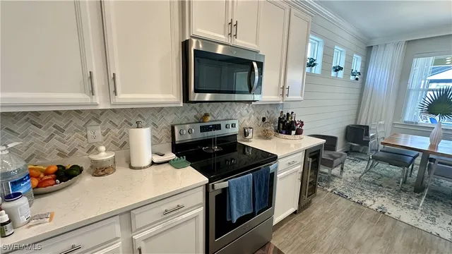 a kitchen with stainless steel appliances granite countertop a table chairs microwave and sink