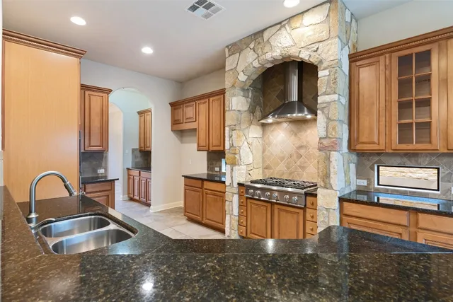 a kitchen with granite countertop a stove and a sink