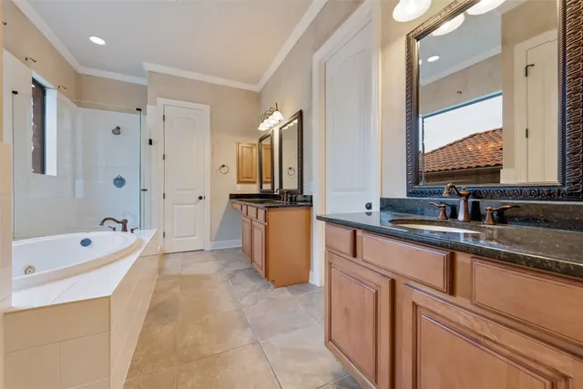 a large bathroom with a double vanity sink a mirror and a bathtub