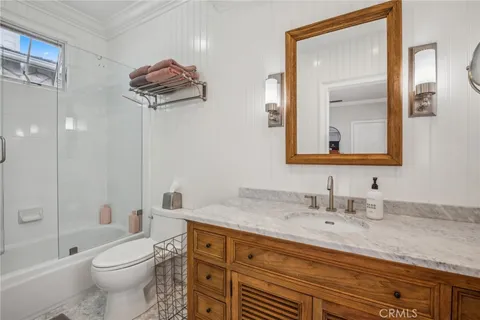 a bathroom with a granite countertop sink a toilet and shower