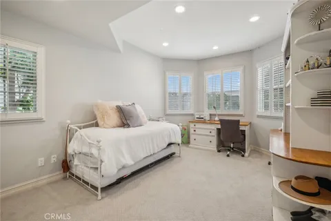 a bedroom with a bed and large windows