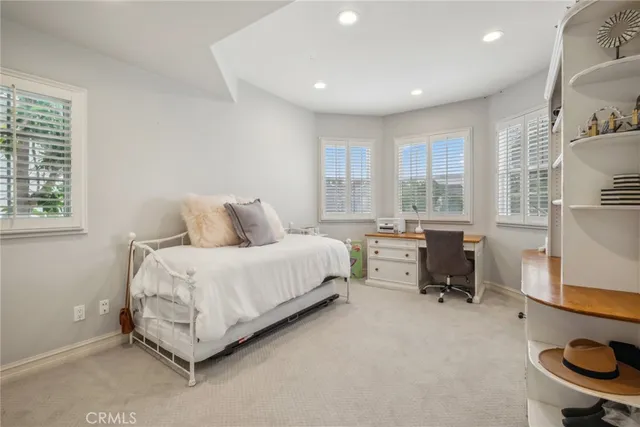 a bedroom with a bed and large windows