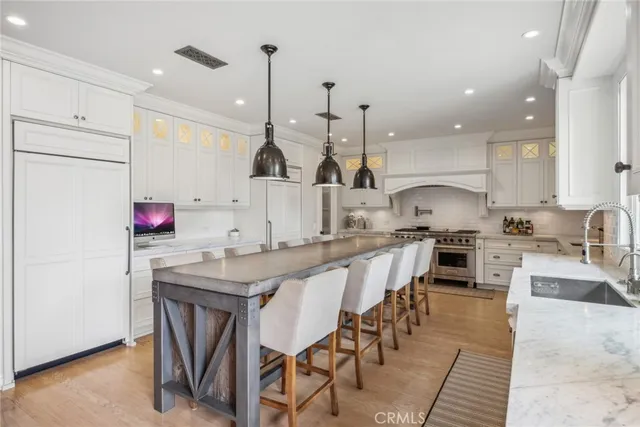 a kitchen with stainless steel appliances granite countertop a sink a stove and a refrigerator