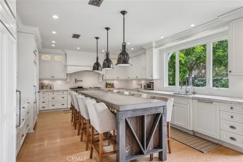 a kitchen with white cabinets and sink