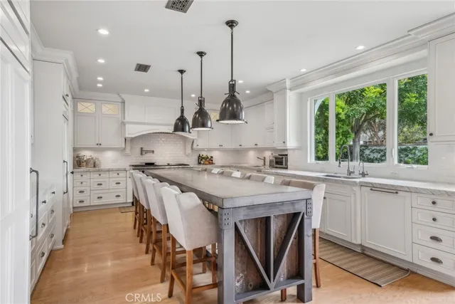 a kitchen with white cabinets and sink