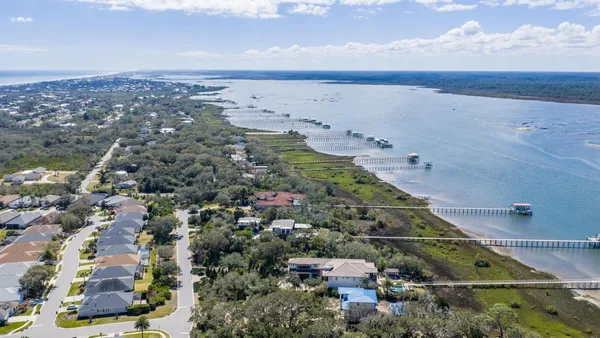 an aerial view of a house with a yard and lake view