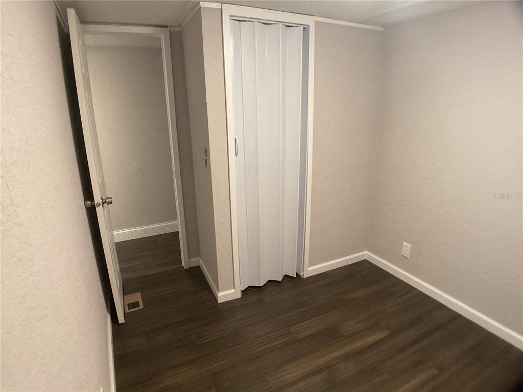 5038 Northeast Sandy Road Arcadia, FL 34266 - Photo 17 of 42 an empty room with wooden floor and entrance
