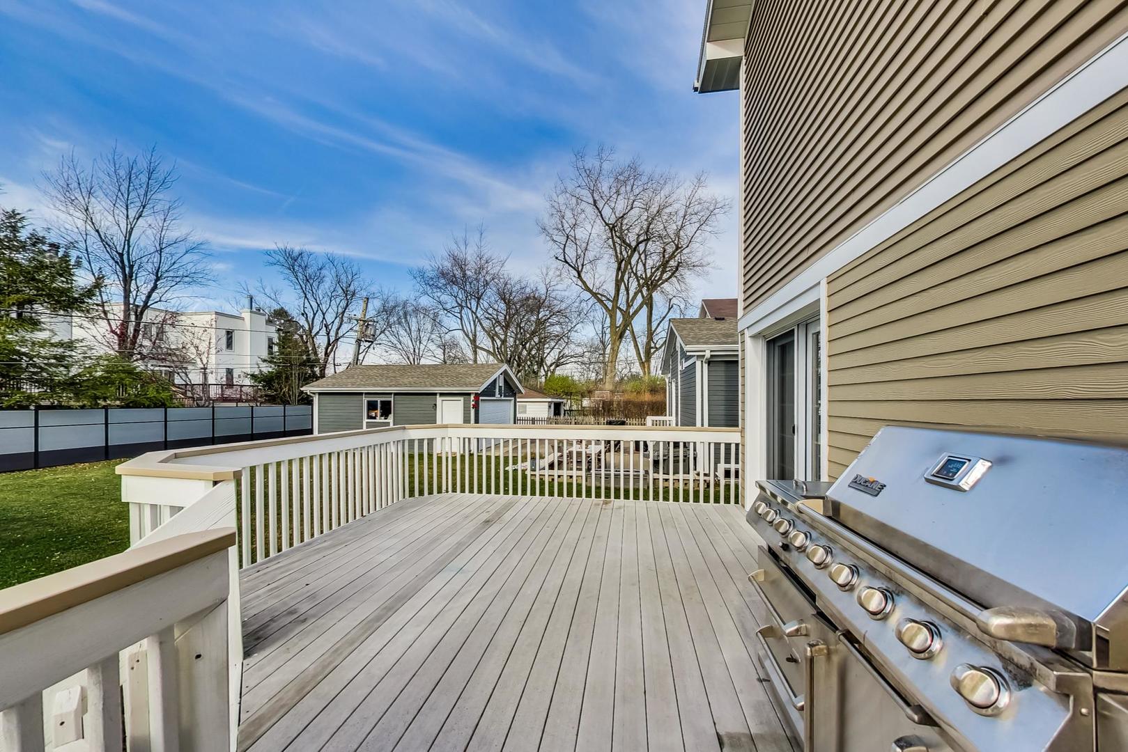 482 Sumac Road Highland Park, IL 60035 - Photo 24 of 29 a view of a deck with wooden floor and fence with a large tree