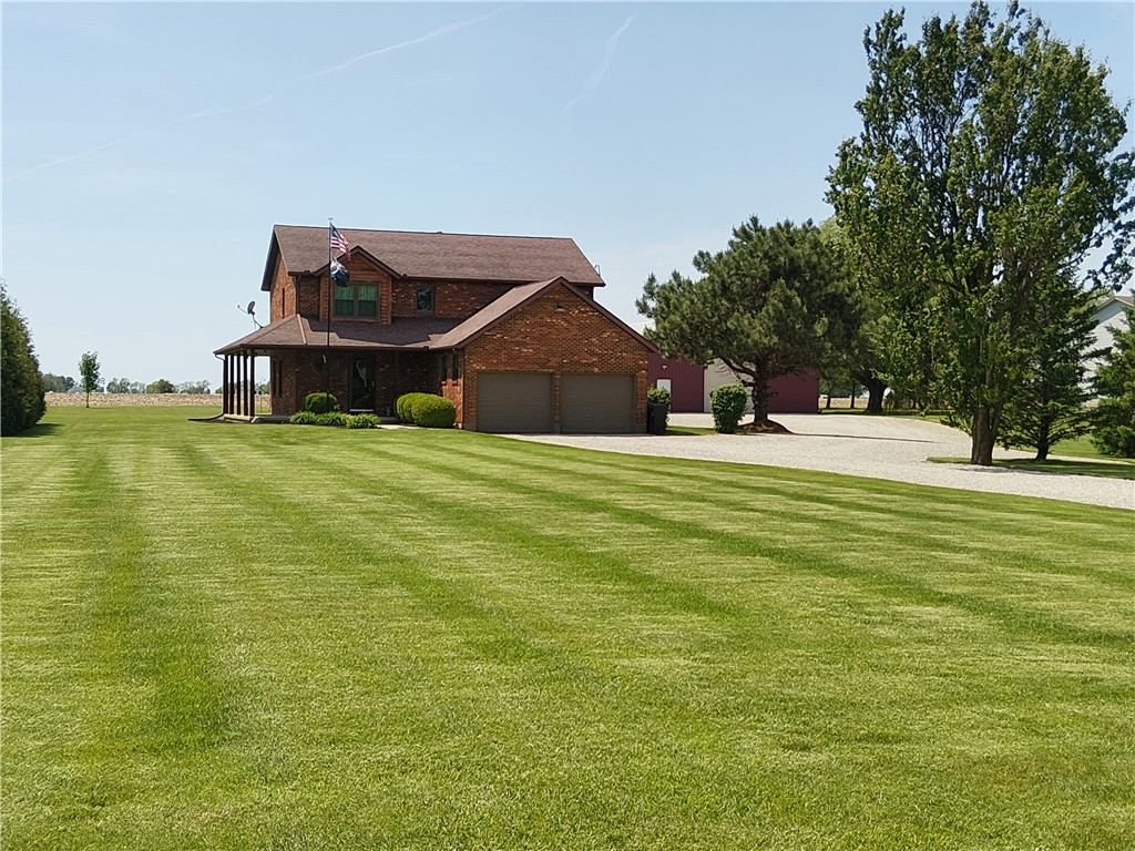 646 North Rangeline Road Pleasant Hill, OH 45359 - Photo 8 of 11 This brick residence offers a spacious, manicured lawn and a welcoming covered porch, perfect for enjoying the outdoors.