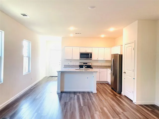 a kitchen with stainless steel appliances a refrigerator and a stove top oven