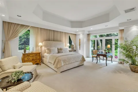 a bedroom with furniture and a large window