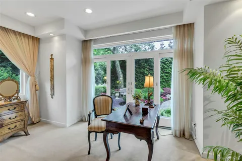 a view of a workspace with furniture and a window