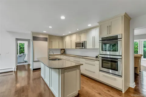 a kitchen with stainless steel appliances granite countertop a stove top oven a sink and a refrigerator