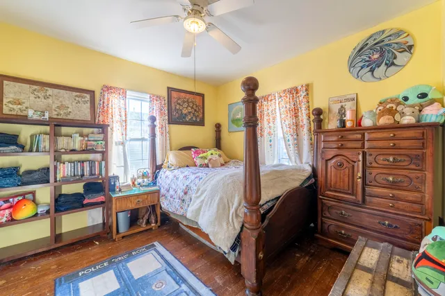 a bedroom with a bed and a bookshelf with wooden floor